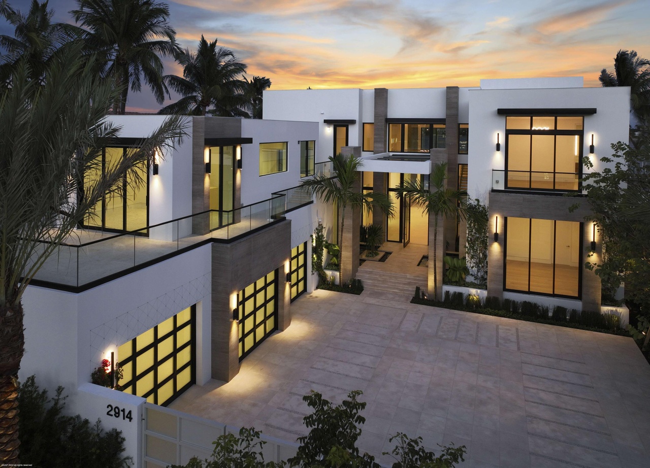 Contemporary waterfront residence in West Palm Beach with sculpted modern architecture at sunset.